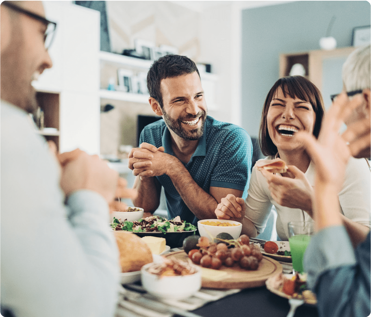 Group enjoying a meal and laughing together.